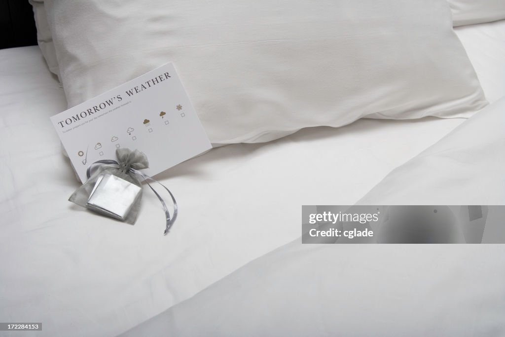 Close-up of chocolates on a turned-down hotel bed