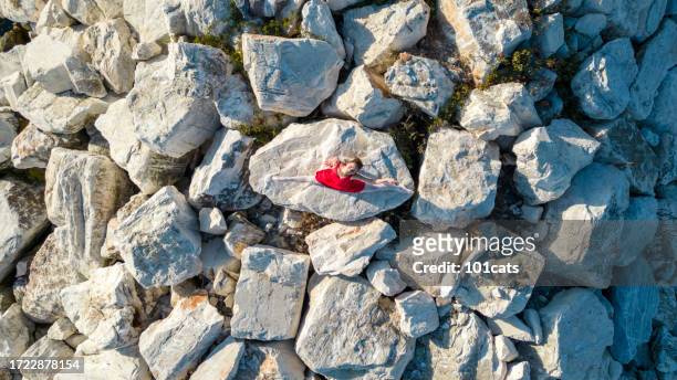 ballerina dancing on the rocks in her red dress - glamour live show fashion shows stock pictures, royalty-free photos & images