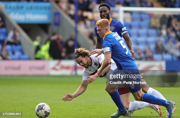 Louis Appéré of Northampton Town goes to ground under the challenge of Morgan Feeney and Chey Dunkley of Shrewsbury Town during the Sky Bet League...