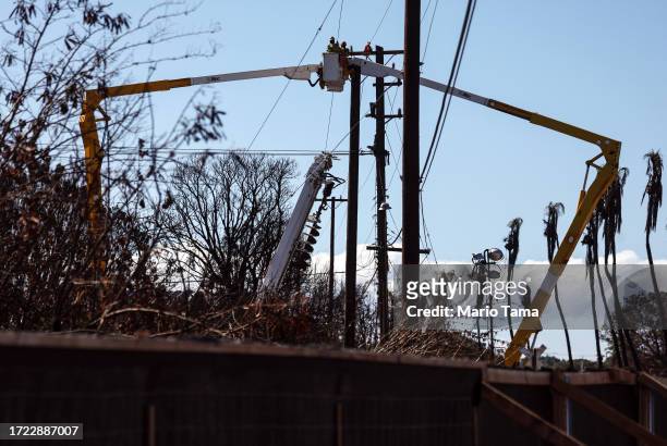 Workers repair utility lines nearly two months after a devastating wildfire on October 07, 2023 in Lahaina, Hawaii. The wind-whipped wildfire on...