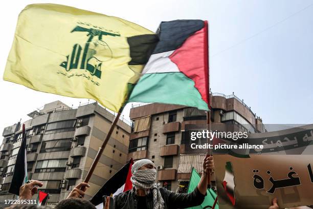 October 2023, Lebanon, Beirut: Lebanese protesters carry Hezbollah and Palestinian flags in solidarity with Palestinians, as fighting between Israeli...