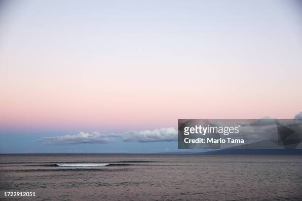 Wave breaks on the Pacific Ocean before sunrise nearly two months after a devastating wildfire on October 07, 2023 near Lahaina, Hawaii. The...