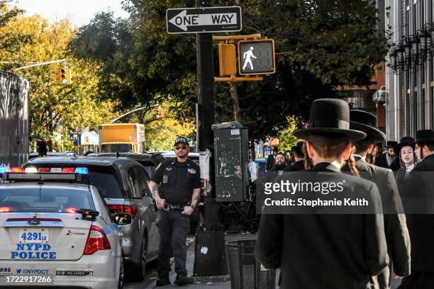 Member of the New York Police Department patrols in front of the synagogue Congregation Bais Yaakov Nechamia Dsatmar on October 13, 2023 in the...