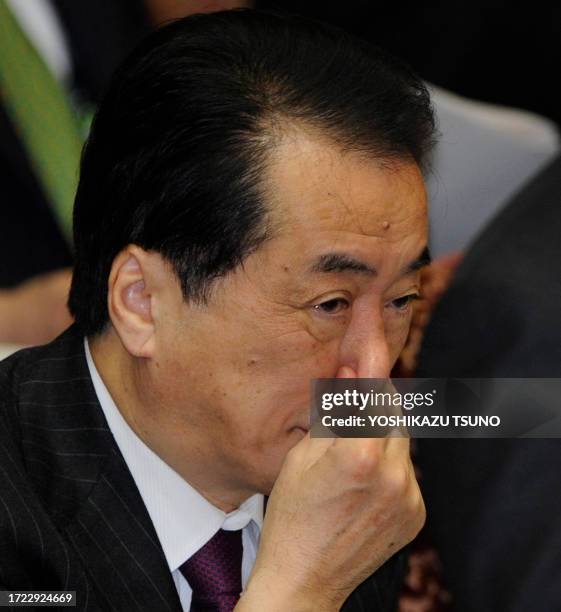 Japanese Prime Minister Naoto Kan pinches his nose during the Upper House's budget committee session at the National Diet in Tokyo on March 7 one day...