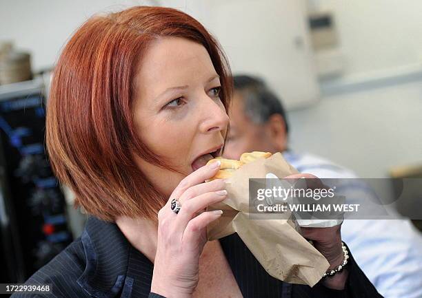 Australia's Prime Minister Julia Gillard tries a meat pie during a visit to a bakery called the 'Pie Minister', in the outer Melbourne suburb of...