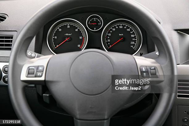 fragment of car dashboard with steering wheel and meters - kilometer stockfoto's en -beelden