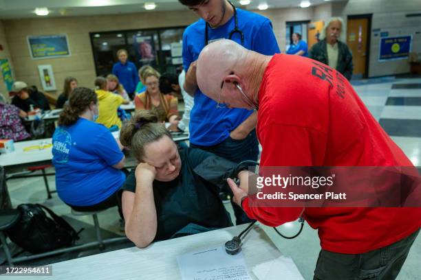 Patients have their blood pressure checked and other vitals taken at a intake triage at a Remote Area Medical mobile dental and medical clinic on...