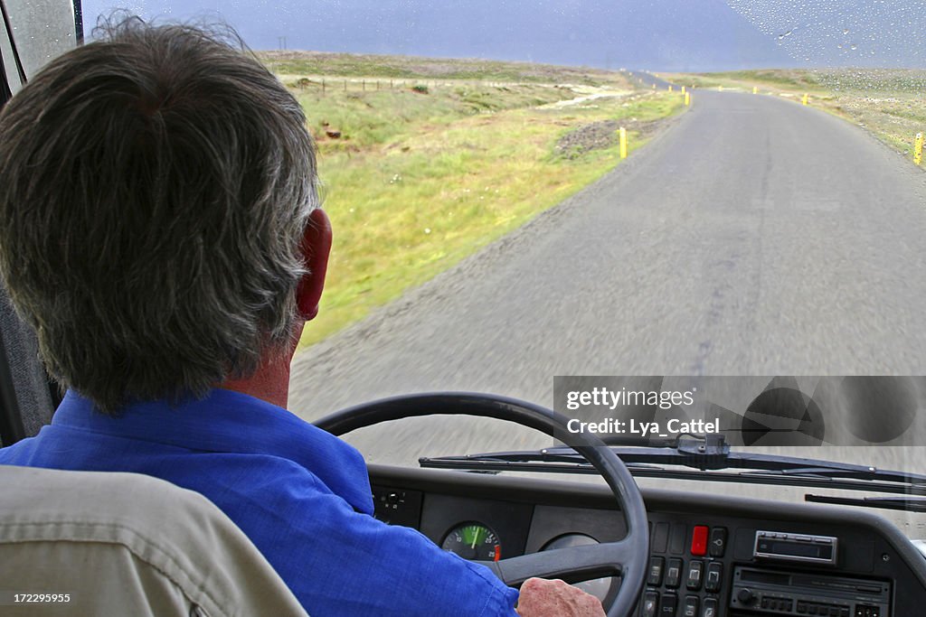 Bus driver on empty road with rainy weather