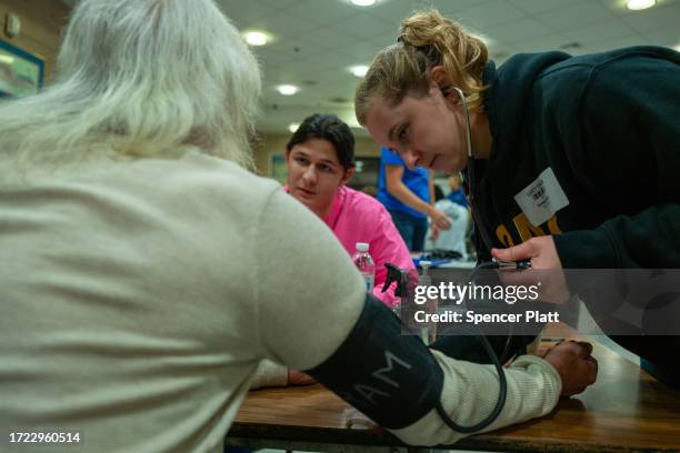 Patients have their blood pressure checked and other vitals taken at a intake triage at a Remote Area Medical mobile dental and medical clinic on...