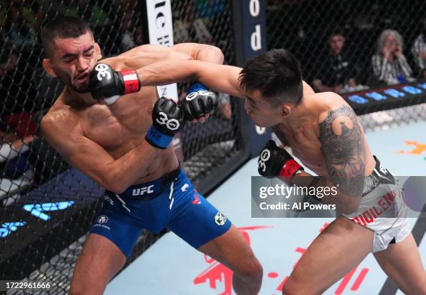 Aoriqileng of China punches Johnny Munoz in a bantamweight fight during the UFC Fight Night weigh-in at UFC APEX on October 07, 2023 in Las Vegas,...