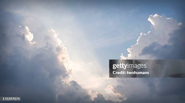 an opening in grey clouds revealing sunlight showing the way - twohumans bildbanksfoton och bilder