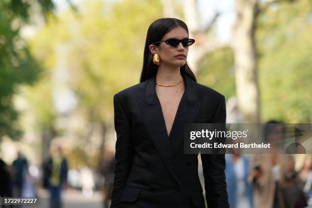 Sara Sampaio wears sunglasses, earrings, a black oversized double breasted blazer jacket with shoulder pads, outside Zimmermann, during the...