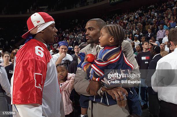 Rapper Master P talks to Cuttino Mobley of the Houston Rockets and his son after performing with Lil' Romeo following the game between the Houston...