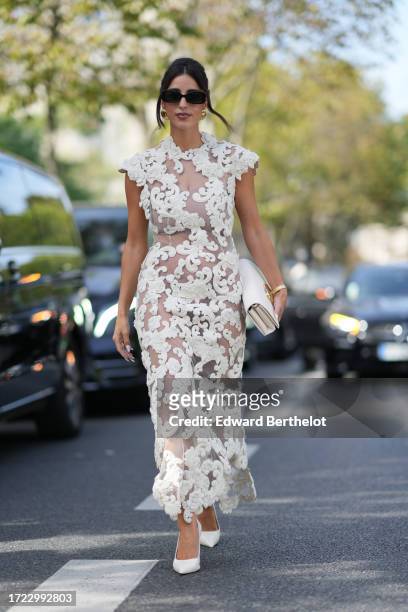 Bettina Looney wears sunglasses, a white mesh dress with floral embroidery, a bag, pointed shoes, outside Zimmermann, during the Womenswear...