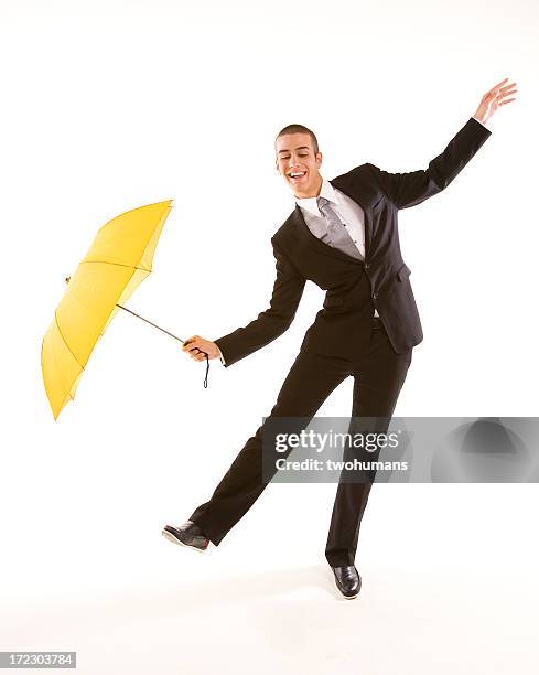 man in suit with yellow umbrella doing funny business - twohumans stock pictures, royalty-free photos & images