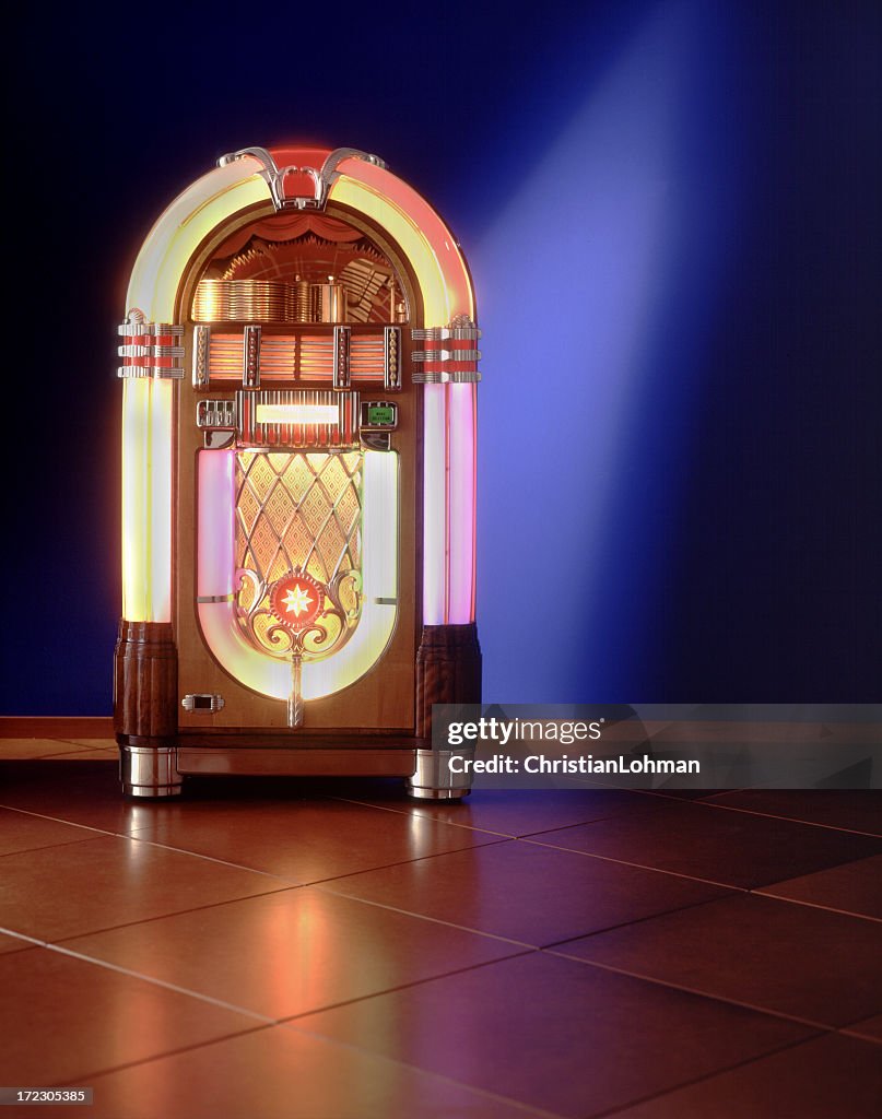 Lit up jukebox against a blue wall