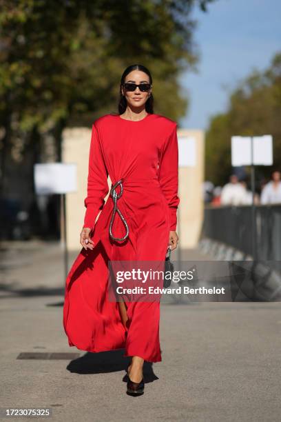 Tamara Kalinic wears a red gathered dress, outside Stella McCartney, during the Womenswear Spring/Summer 2024 as part of Paris Fashion Week on...