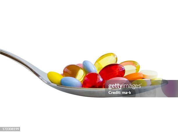spoonful of medicine pills and capsules - spoon stock pictures, royalty-free photos & images