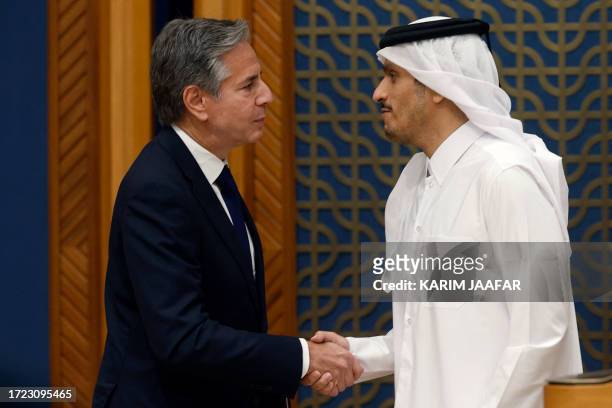 Secretary of State Antony Blinken shakes hands with Qatar's Prime Minister and Foreign Minister Mohammed bin Abdulrahman Al Thani following their...