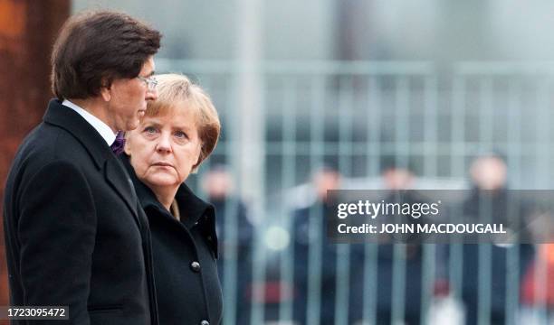 German Chancellor Angela Merkel and Belgian Prime Minister Elio Di Rupo listen to their national anthems during an official welcoming ceremony at the...