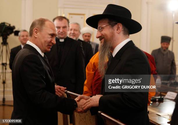 Russia's Prime Minister Vladimir Putin shakes hands with Russia's Chief Rabbi Berel Lazar during his meeting with religious leaders in the Danilov...