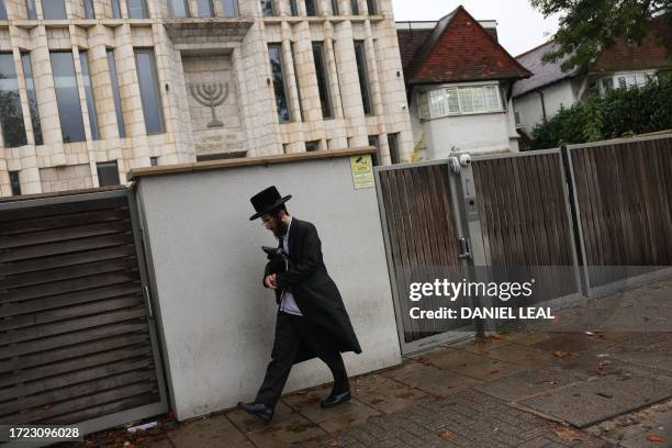 Ultra-Orthodox Jew walks past a synagogue in north London on October 13, 2023. The UK government announced Thursday £3 million of extra funding to...