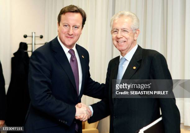 Britain Prime Minister David Cameron and Italy Prime Minister Mario Monti shakes hand as they meet before an informal dinner gathering European Union...