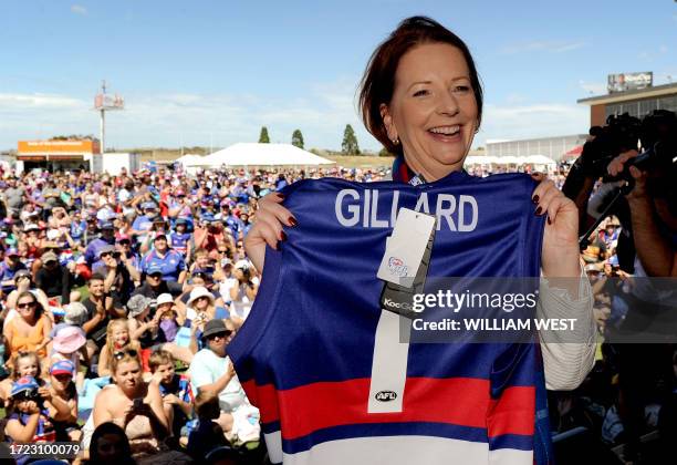 Australian Prime Minister and Western Bulldogs number one ticket holder, Julia Gillard, poses with a team jumper as the Australian Rules team holds a...