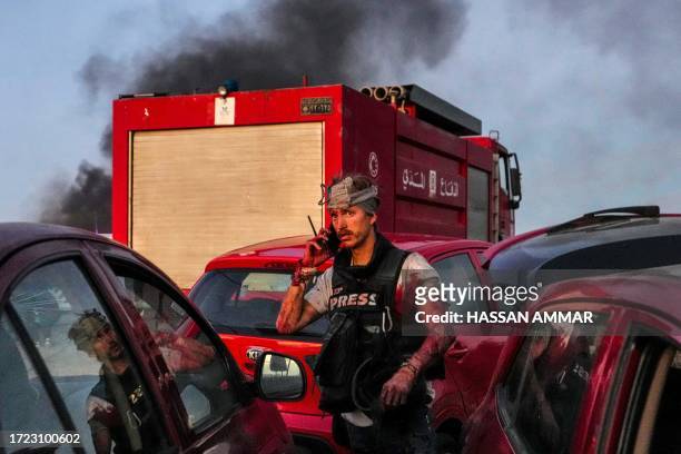 Graphic content / TOPSHOT - This picture provided courtesy of the Associated Press shows AFP cameraman Dylan Collins speaking on his mobile phone...