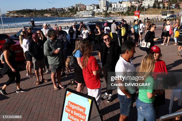 Voters queue up outside a polling station on Bondi Beach in Sydney on October 14, 2023 as polls open in Australia's historic Indigenous rights...