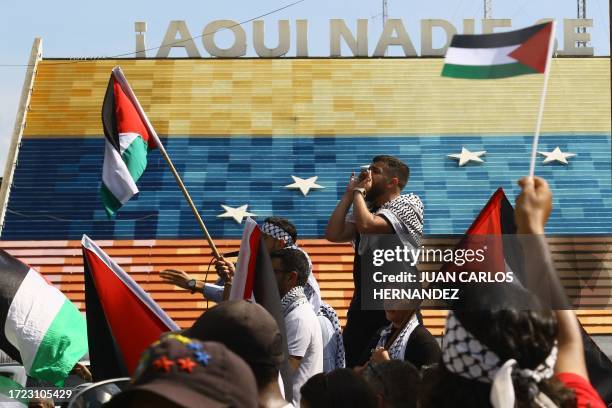 People wave Palestinian flags during a protest in support of Palestinians in Valencia, Carabobo State, Venezuela, on October 13, 2023 amid Israeli...