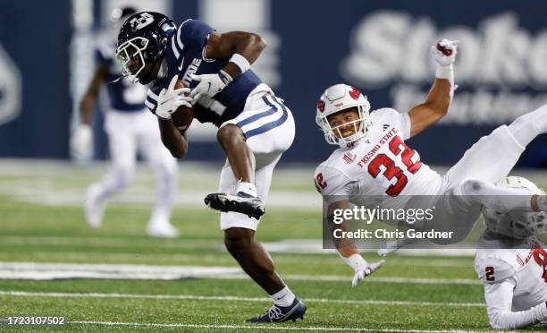 Jaylen Royals of the Utah State Aggies breaks a tackle attempt by Dean Clark of the Fresno State Bulldogs on his way to score a touchdown during the...