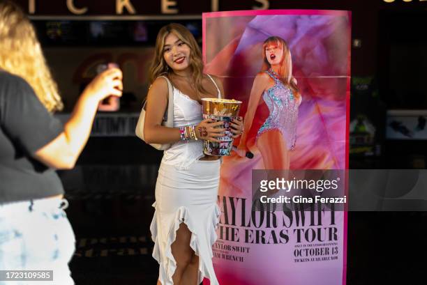 Blake Liu gets her picture taken in front of a Taylor Swift poster before attending Taylor Swift concert movie at the AMC theater on October 13, 2023...