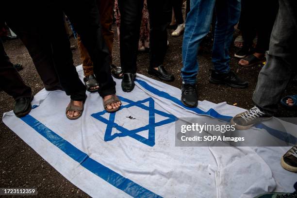 Protesters are seen stepping on the Israeli flag while gathering near the US embassy during the protest. Protesters in Kuala Lumpur marched to the US...