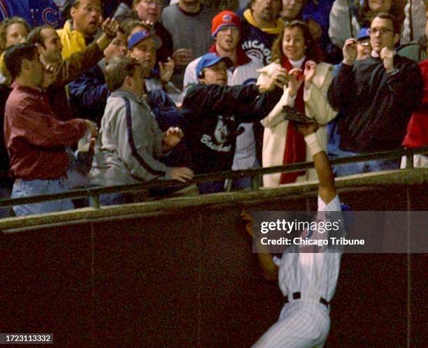 Chicago Cubs fan Steve Bartman and others go for a ball that Cubs left fielder Moises Alou is trying to catch in the eighth inning of Game 6 of the...