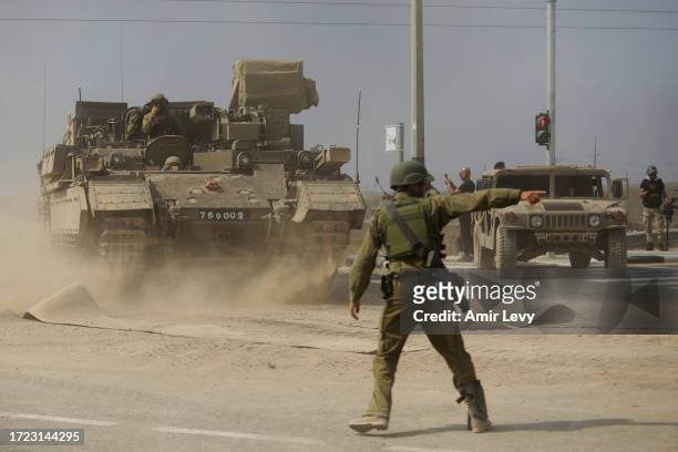 Soldier gives directions to a tank unit near the border with Gaza on October 14, 2023 near Sderot, Israel. Israel has sealed off Gaza and launched...
