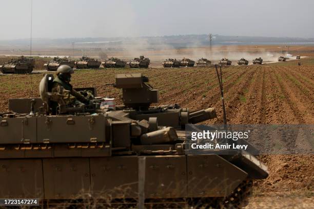 Tanks move in formation near the border with Gaza on October 14, 2023 near Sderot, Israel. Israel has sealed off Gaza and launched sustained...