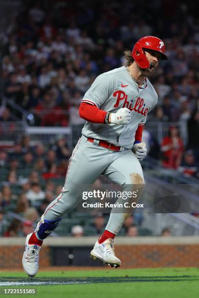 Bryce Harper of the Philadelphia Phillies round bases and reacts after hitting a solo home run during the sixth inning against the Atlanta Braves...