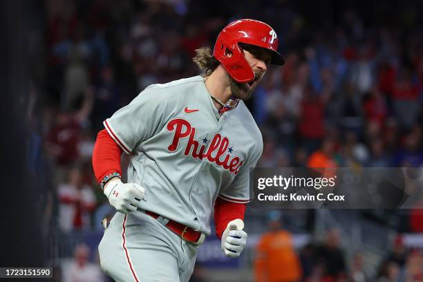 Bryce Harper of the Philadelphia Phillies round bases and reacts after hitting a solo home run during the sixth inning against the Atlanta Braves...