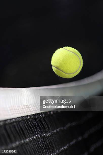 yellow tennis ball over the net - tennisbal stockfoto's en -beelden