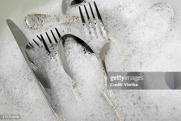 cutlery and utensils in soap suds - bestek stockfoto's en -beelden