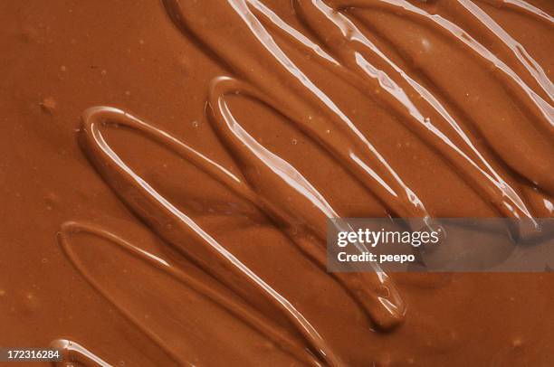 abstract squiggle pattern in molten milk chocolate. - chocolate melting stock pictures, royalty-free photos & images