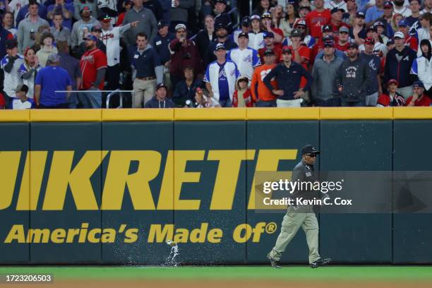 Grounds security member collects objects thrown onto the field during the eighth inning between the Atlanta Braves and the Philadelphia Phillies...
