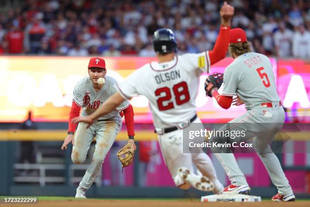 Trea Turner of the Philadelphia Phillies passes the ball to Bryson Stott during fourth inning against the Atlanta Braves Game One of the Division...