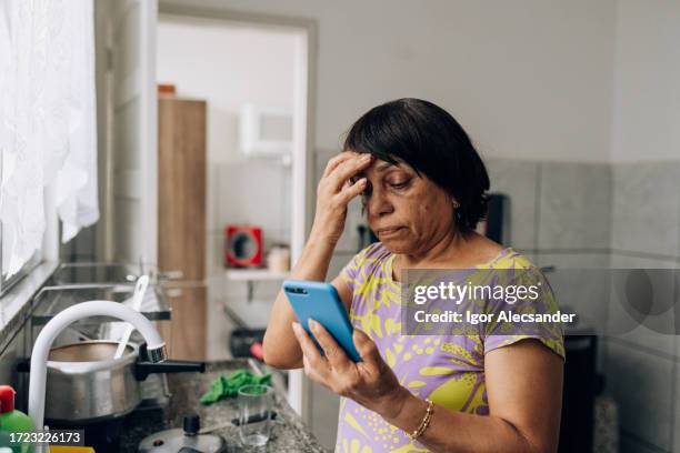 worried woman accessing mobile application - female worried mobile imagens e fotografias de stock