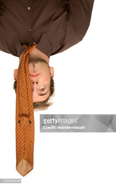 businessman is hanging upside down having stress - draped stockfoto's en -beelden