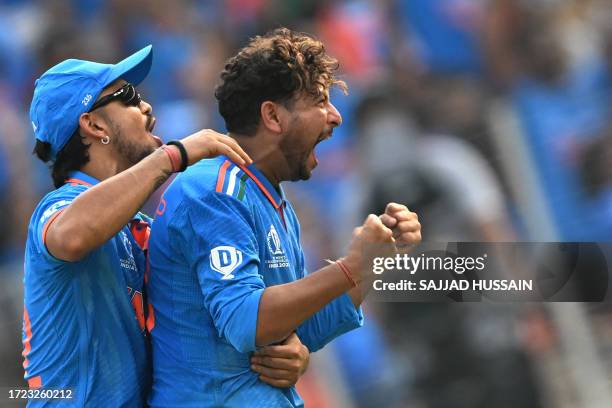 India's Kuldeep Yadav celebrates with teammate Ishan Kishan after taking the wicket of Pakistan's Saud Shakeel during the 2023 ICC Men's Cricket...