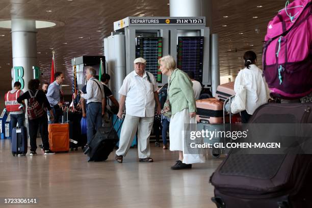 Graphic content / Travellers arrive to check-in at Ben Gurion International Airport near Tel Aviv on October 14 amid the ongoing battles between...