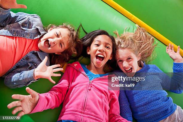 girls lying down in bounce house - bouncing stock pictures, royalty-free photos & images