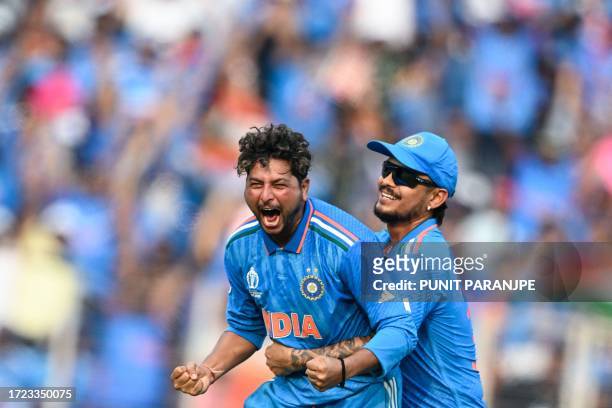 India's Kuldeep Yadav celebrates with teammate Ishan Kishan after taking the wicket of Pakistan's Saud Shakeel during the 2023 ICC Men's Cricket...